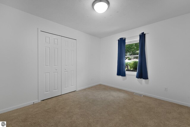 5151 Hidden Gables Dr, Traverse City, MI 49684 - unfurnished bedroom featuring carpet and a closet