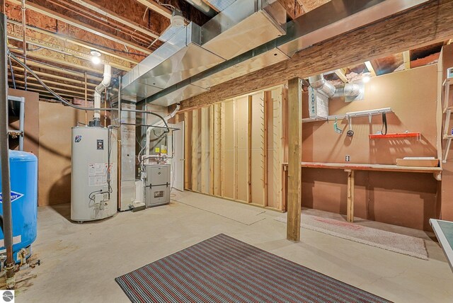 5151 Hidden Gables Dr, Traverse City, MI 49684 - unfinished below grade area with gas water heater, heating unit, and a water pressure tank