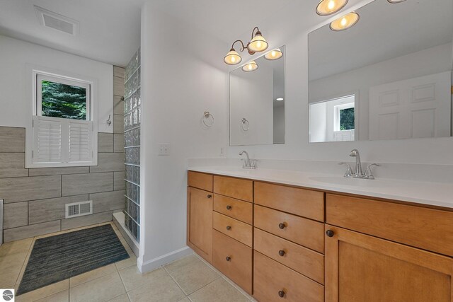5151 Hidden Gables Dr, Traverse City, MI 49684 - bathroom featuring tile patterned flooring, healthy amount of natural light, double vanity, and tiled shower