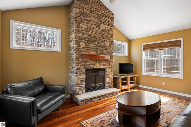 5151 Hidden Gables Dr, Traverse City, MI 49684 - living area featuring lofted ceiling, a fireplace, and wood finished floors