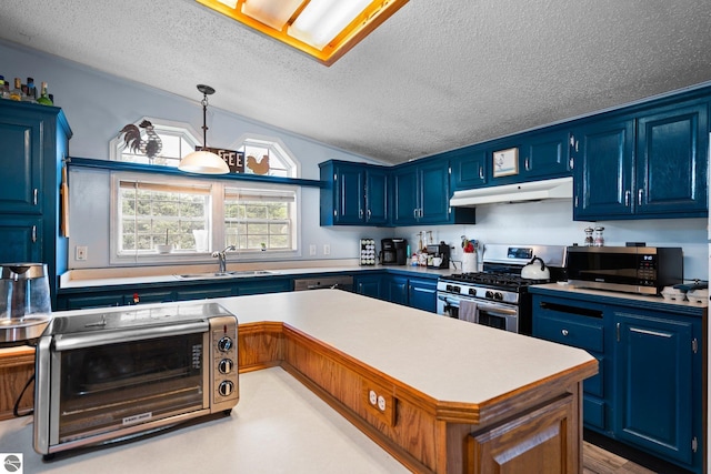9170 Townline Rd, Kingsley, MI 49649 - kitchen featuring stainless steel appliances, under cabinet range hood, blue cabinets, a textured ceiling, and a sink