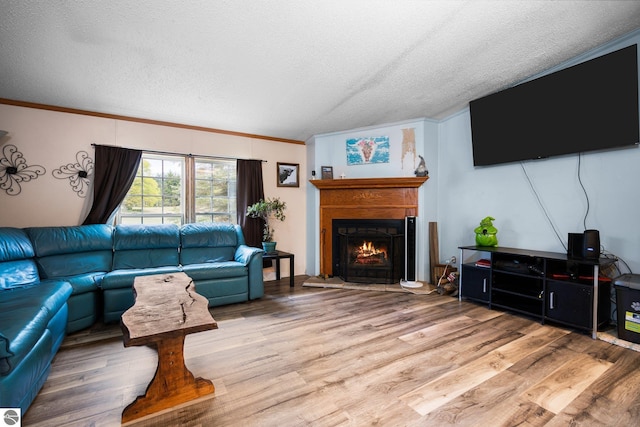 9170 Townline Rd, Kingsley, MI 49649 - living area with light wood-style flooring, a lit fireplace, a textured ceiling, and ornamental molding