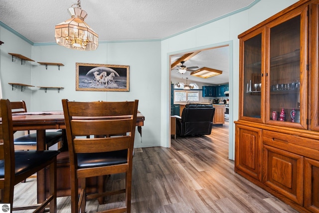 9170 Townline Rd, Kingsley, MI 49649 - dining space with wood finished floors, a textured ceiling, ornamental molding, ceiling fan, and a chandelier
