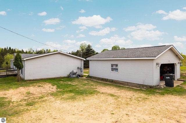 9170 Townline Rd, Kingsley, MI 49649 - view of side of home with an outbuilding, a detached garage, a yard, and roof with shingles