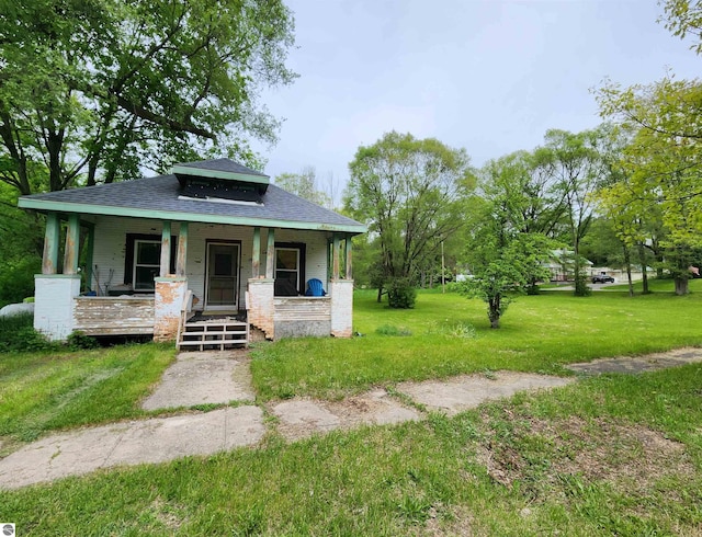 18846 Maple St, Copemish, MI 49625 - view of front of home with a porch, roof with shingles, and a front yard