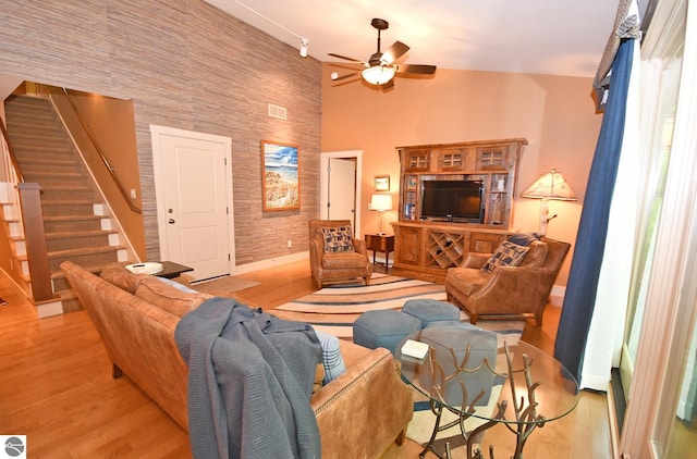 4365 W Burdickville Rd, Maple City, MI 49664 - living area with ceiling fan, wood finished floors, baseboards, stairs, and a high ceiling