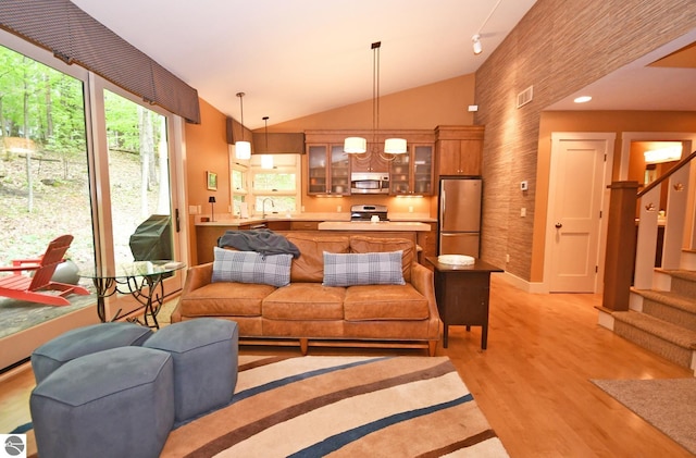 4365 W Burdickville Rd, Maple City, MI 49664 - living room featuring light wood-type flooring, stairway, and lofted ceiling