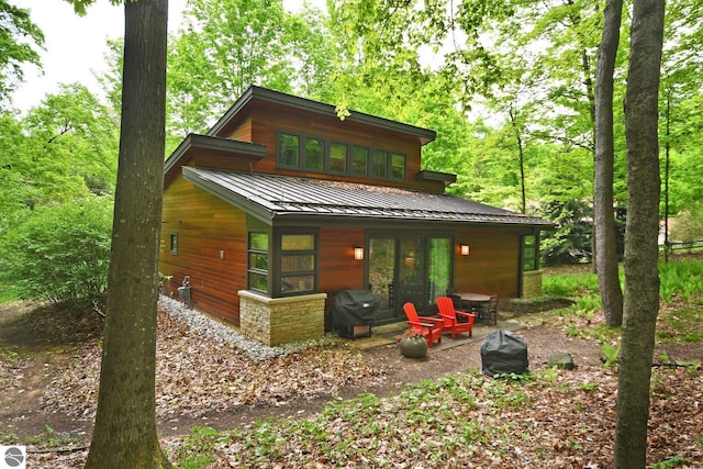 4365 W Burdickville Rd, Maple City, MI 49664 - rear view of property featuring french doors, a standing seam roof, metal roof, and stone siding