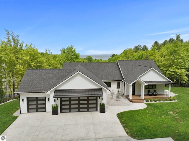 6848 S Carol Ann Dr, Traverse City, MI 49684 - modern farmhouse style home with an attached garage, a front lawn, roof with shingles, and concrete driveway