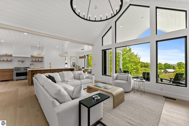 6848 S Carol Ann Dr, Traverse City, MI 49684 - living room with light wood-style floors, baseboards, high vaulted ceiling, and recessed lighting