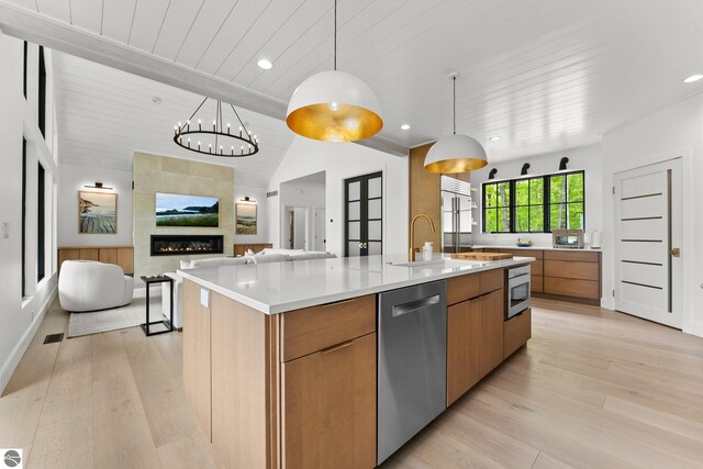 6848 S Carol Ann Dr, Traverse City, MI 49684 - kitchen with appliances with stainless steel finishes, modern cabinets, brown cabinets, open floor plan, and light wood-style flooring