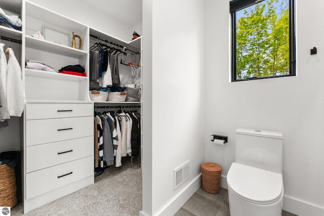 6848 S Carol Ann Dr, Traverse City, MI 49684 - bathroom with toilet, baseboards, and a walk in closet