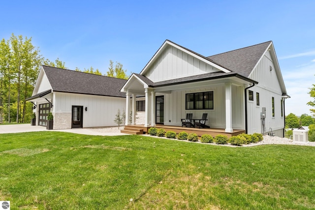 6848 S Carol Ann Dr, Traverse City, MI 49684 - modern farmhouse style home with roof with shingles, board and batten siding, covered porch, and a front yard