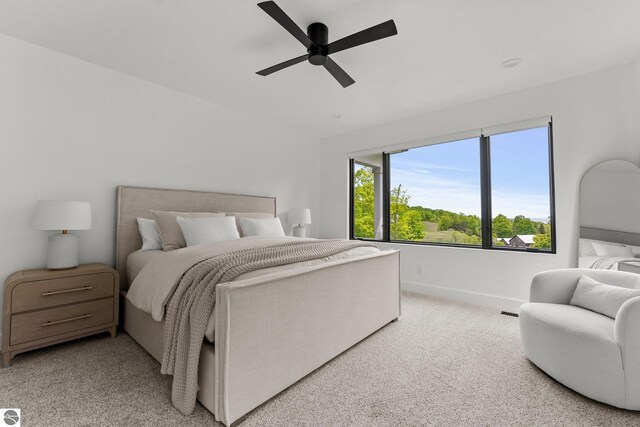 6848 S Carol Ann Dr, Traverse City, MI 49684 - bedroom featuring light carpet, baseboards, and a ceiling fan