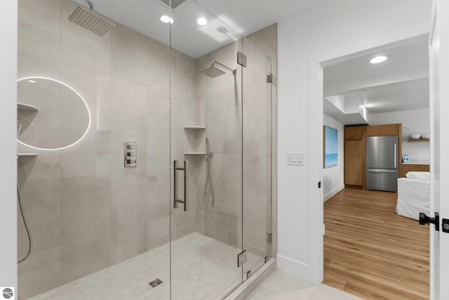 6848 S Carol Ann Dr, Traverse City, MI 49684 - ensuite bathroom featuring a stall shower, wood finished floors, recessed lighting, and baseboards
