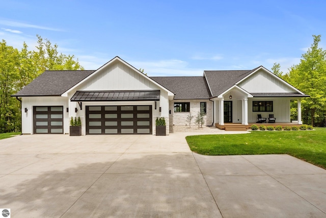 6848 S Carol Ann Dr, Traverse City, MI 49684 - modern farmhouse featuring a garage, a front yard, a standing seam roof, and roof with shingles