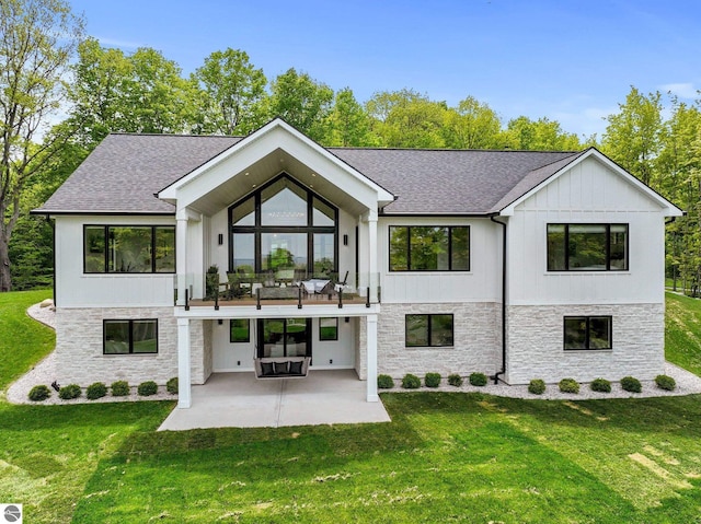 6848 S Carol Ann Dr, Traverse City, MI 49684 - view of front of property featuring stone siding, a patio area, and a front yard