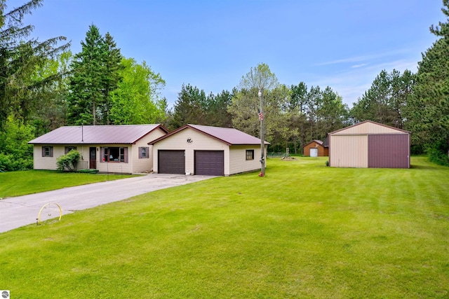 6148 S 27th Rd, Cadillac, MI 49601 - view of front facade with an outbuilding, a front lawn, view of scattered trees, and a detached garage