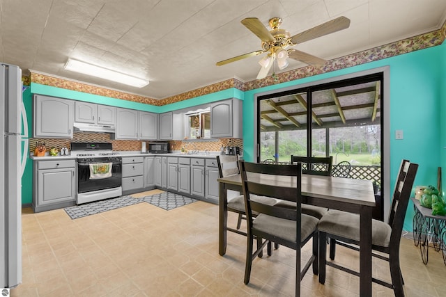 6148 S 27th Rd, Cadillac, MI 49601 - kitchen with white appliances, gray cabinets, under cabinet range hood, tasteful backsplash, and a ceiling fan