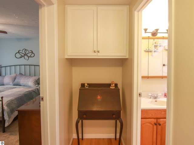 8086 Narrow Gauge Rd, Beulah, MI 49617 - bedroom with a sink, baseboards, wood finished floors, and connected bathroom