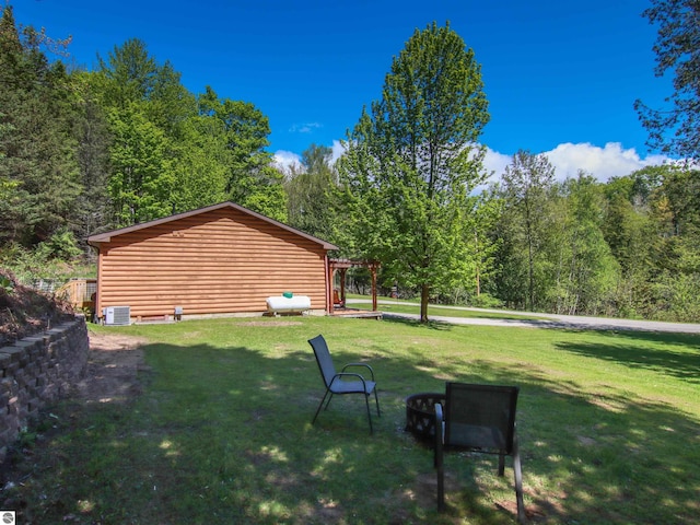 8086 Narrow Gauge Rd, Beulah, MI 49617 - view of green lawn with central air condition unit and a wooded view
