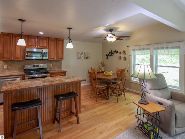 8086 Narrow Gauge Rd, Beulah, MI 49617 - kitchen with appliances with stainless steel finishes, healthy amount of natural light, decorative backsplash, and light wood finished floors