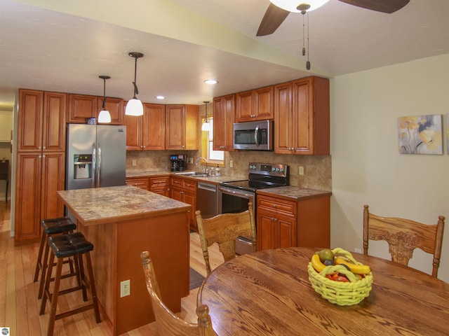 8086 Narrow Gauge Rd, Beulah, MI 49617 - kitchen with stainless steel appliances, light wood-style floors, a sink, a kitchen island, and recessed lighting