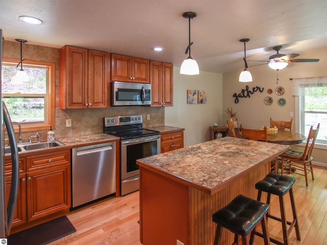 8086 Narrow Gauge Rd, Beulah, MI 49617 - kitchen with appliances with stainless steel finishes, light wood finished floors, a sink, brown cabinets, and recessed lighting