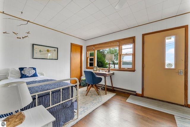 7510 Crystal Dr, Beulah, MI 49616 - bedroom featuring wood finished floors, baseboards, a baseboard heating unit, ornamental molding, and an office area