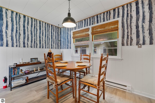 7510 Crystal Dr, Beulah, MI 49616 - dining room featuring baseboard heating, wood finished floors, wallpapered walls, and a wainscoted wall