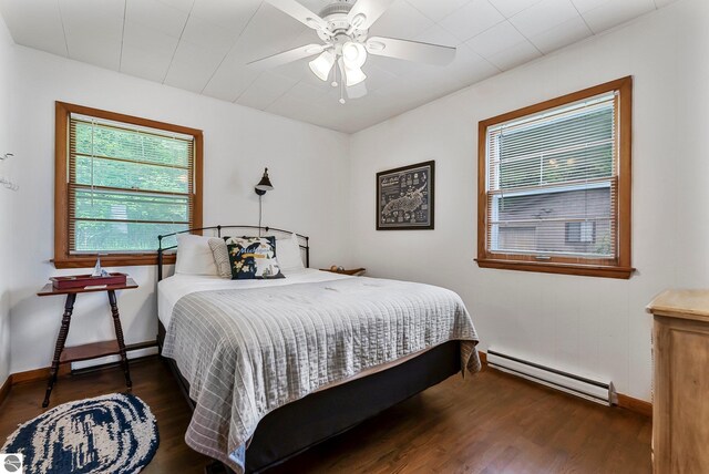 7510 Crystal Dr, Beulah, MI 49616 - bedroom featuring baseboard heating, wood finished floors, baseboards, and ceiling fan