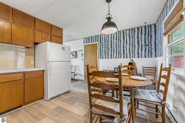 7510 Crystal Dr, Beulah, MI 49616 - dining room with light wood-style flooring, wainscoting, and wallpapered walls
