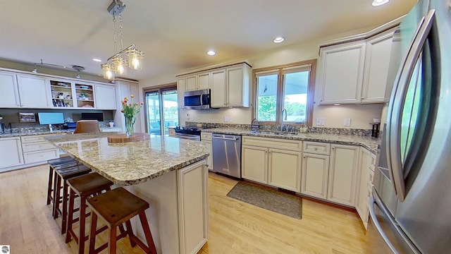 2152 Cornerstone Dr, Mount Pleasant, MI 48858 - kitchen featuring appliances with stainless steel finishes, a sink, light wood-type flooring, a kitchen breakfast bar, and recessed lighting