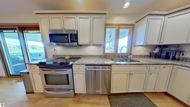 2152 Cornerstone Dr, Mount Pleasant, MI 48858 - kitchen featuring appliances with stainless steel finishes, a sink, light wood finished floors, recessed lighting, and light stone countertops