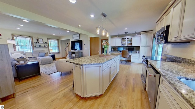 2152 Cornerstone Dr, Mount Pleasant, MI 48858 - kitchen with light wood-style flooring, hanging light fixtures, light stone countertops, recessed lighting, and a center island