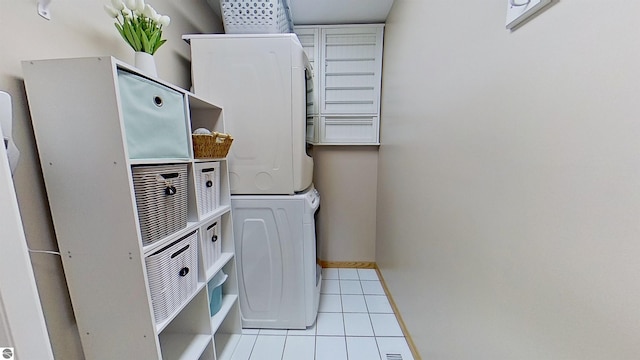 2152 Cornerstone Dr, Mount Pleasant, MI 48858 - laundry area featuring estacked washer and dryer, tile patterned floors, and baseboards