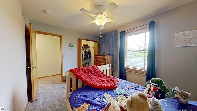 2152 Cornerstone Dr, Mount Pleasant, MI 48858 - carpeted bedroom featuring a walk in closet, a ceiling fan, and baseboards