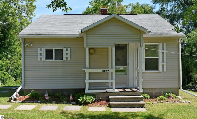 4327 S M-65, Glennie, MI 48737 - bungalow-style house with a chimney, a front lawn, and a shingled roof