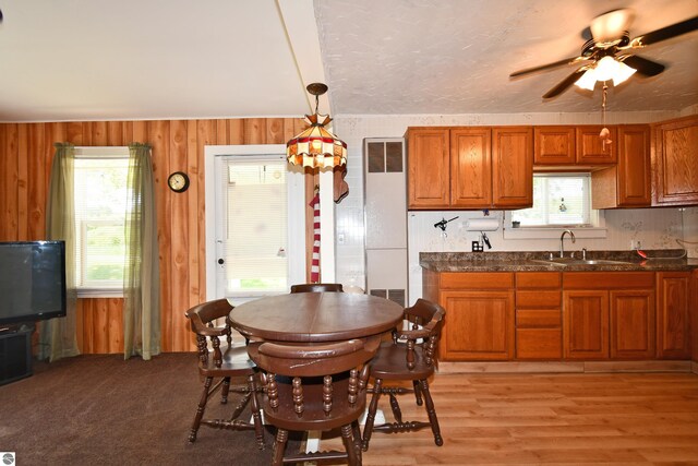 4327 S M-65, Glennie, MI 48737 - kitchen featuring a sink, brown cabinets, dark countertops, and wooden walls