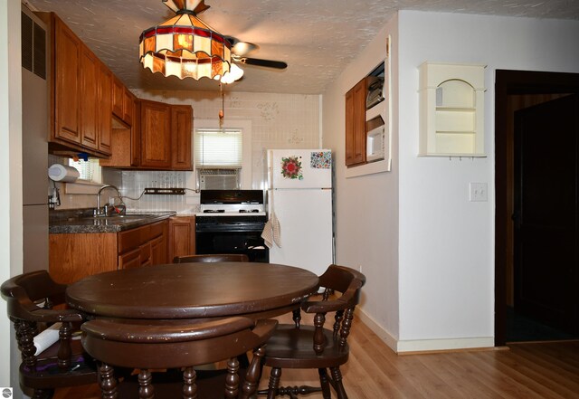 4327 S M-65, Glennie, MI 48737 - kitchen with white appliances, brown cabinets, light wood-type flooring, and a sink