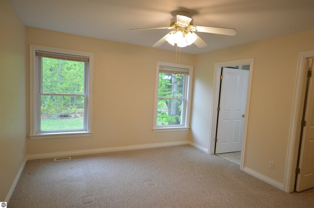 1433 Elk Run, Traverse City, MI 49696 - empty room featuring light colored carpet, a ceiling fan, and baseboards