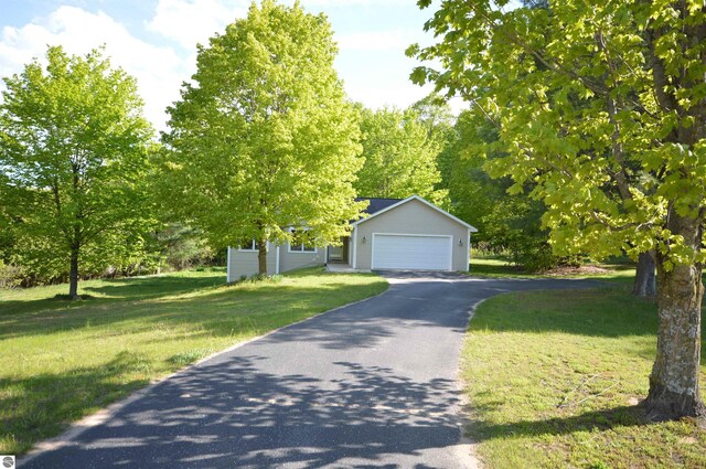 1433 Elk Run, Traverse City, MI 49696 - view of property hidden behind natural elements featuring a front lawn and a detached garage
