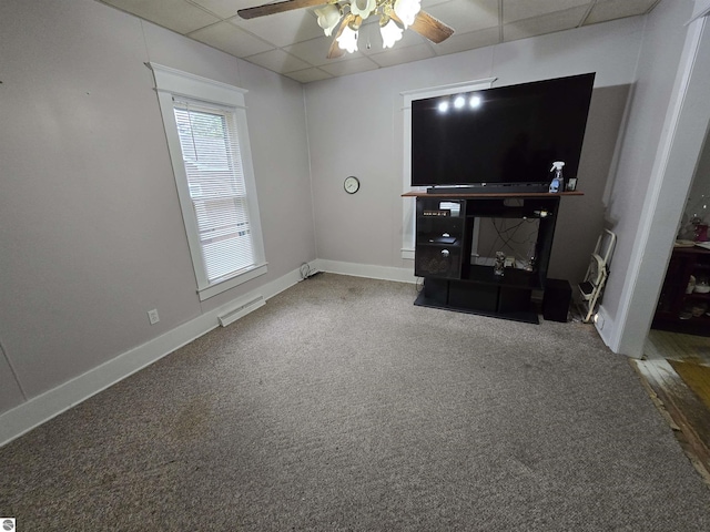 820 Wallace St, Cadillac, MI 49601 - unfurnished living room featuring a paneled ceiling, a ceiling fan, carpet, and baseboards