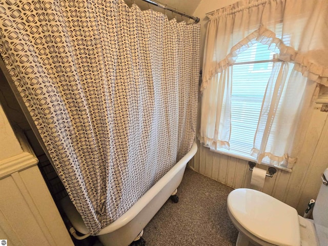 820 Wallace St, Cadillac, MI 49601 - full bathroom featuring a soaking tub, toilet, a shower with curtain, and wooden walls