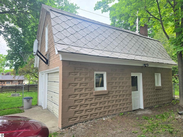820 Wallace St, Cadillac, MI 49601 - view of home's exterior with a chimney, stone siding, and a shingled roof