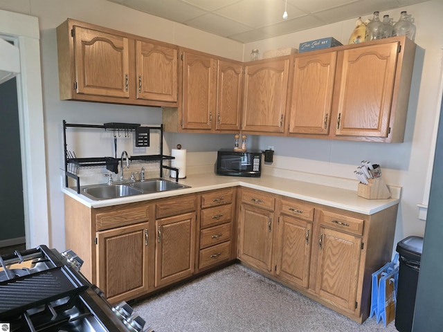 820 Wallace St, Cadillac, MI 49601 - kitchen with a sink, black microwave, light countertops, and brown cabinetry