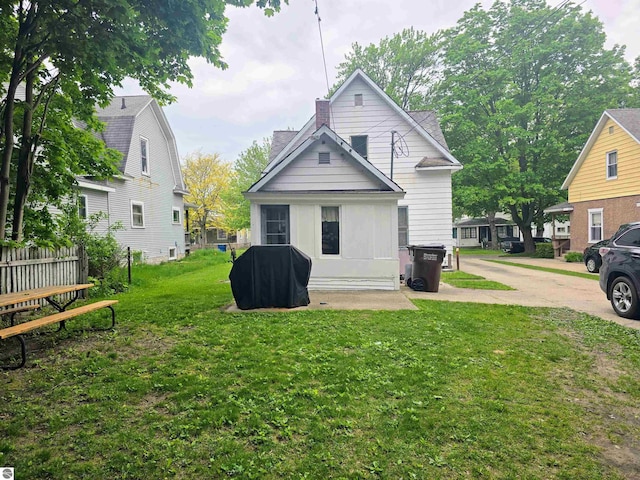 820 Wallace St, Cadillac, MI 49601 - rear view of house featuring a lawn