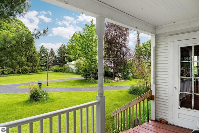 9889 Ramsay Rd, Buckley, MI 49620 - wooden porch with a lawn and view of scattered trees