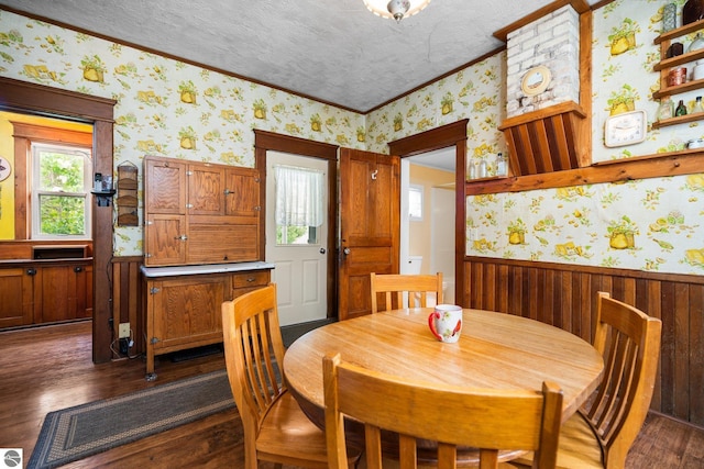 9889 Ramsay Rd, Buckley, MI 49620 - dining area featuring wallpapered walls, crown molding, wainscoting, dark wood-style flooring, and wood walls