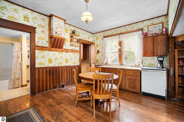 9889 Ramsay Rd, Buckley, MI 49620 - dining space featuring wallpapered walls, ornamental molding, a wainscoted wall, dark wood-style flooring, and a textured ceiling